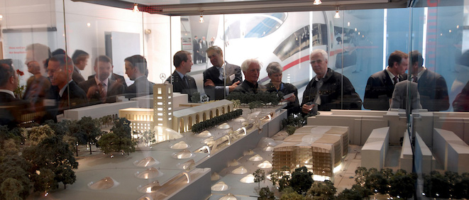 Room of people looking at a model in a bespoke display case